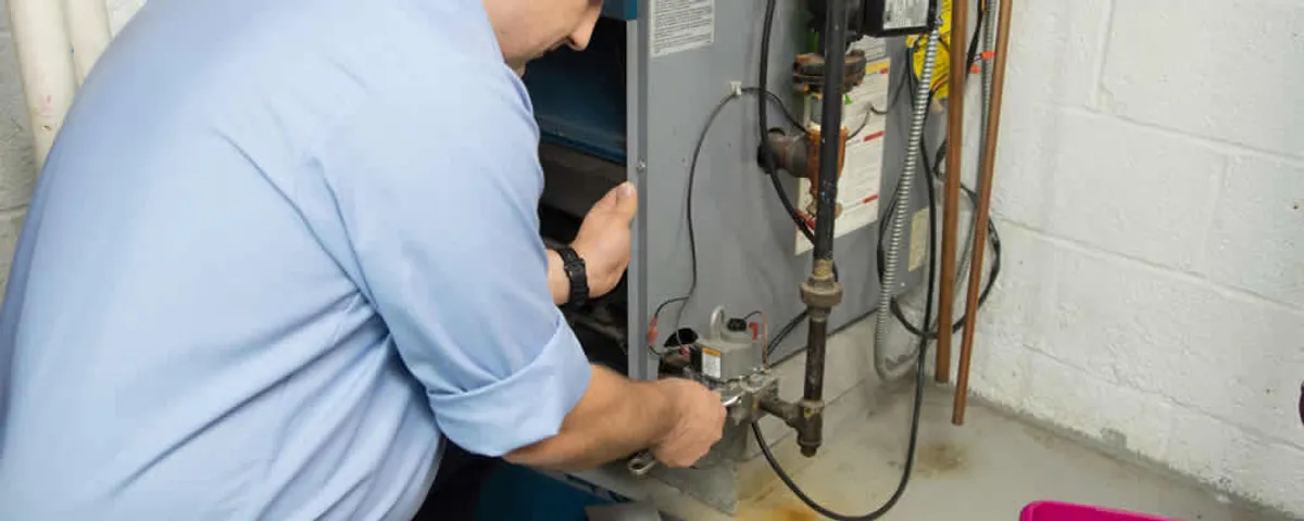 Furnace repair technician inspecting and servicing a home heating system in Beverly, MA