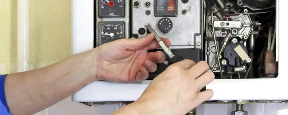 Heating repair technician adjusting boiler controls and components in Beverly, MA