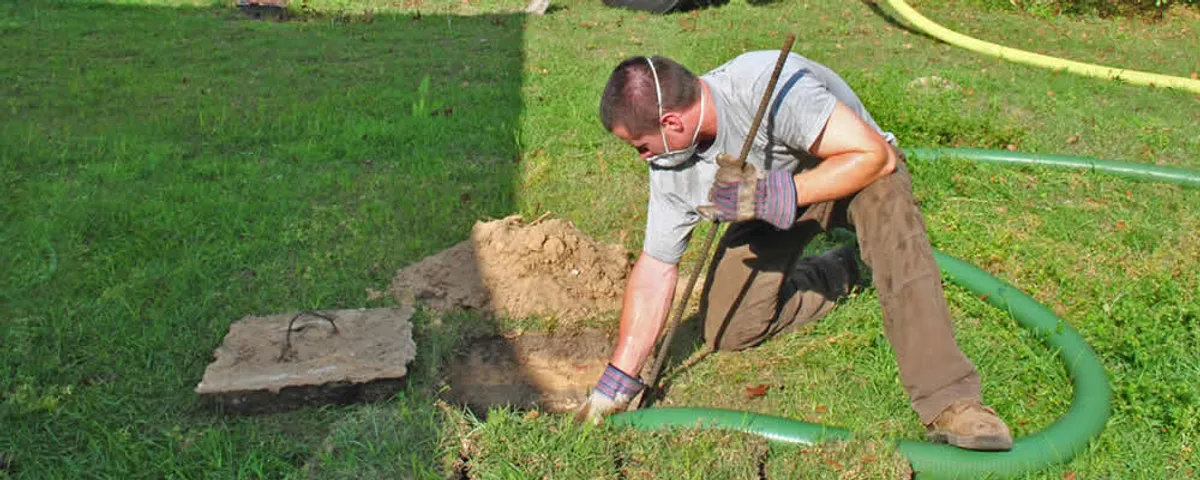 Septic pumping technician servicing a residential septic tank in Beverly, MA