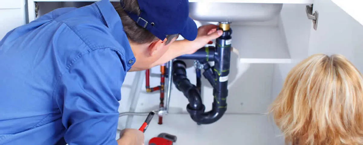 Plumber repairing under-sink drain pipes and fittings in Beverly, MA